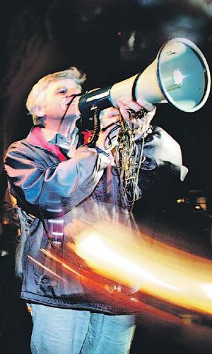 Stralende man met megafoon en veeg van licht in de nacht